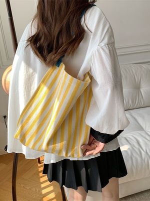 여름에는 눈길을 끄는 대조적인 줄무늬가 있는 두 손잡이 캔버스 어깨 가방이 필수