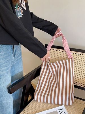 여름에는 눈길을 끄는 대조적인 줄무늬가 있는 두 손잡이 캔버스 어깨 가방이 필수